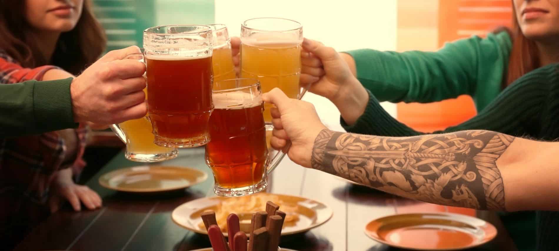 people toasting beer steins at irish pub