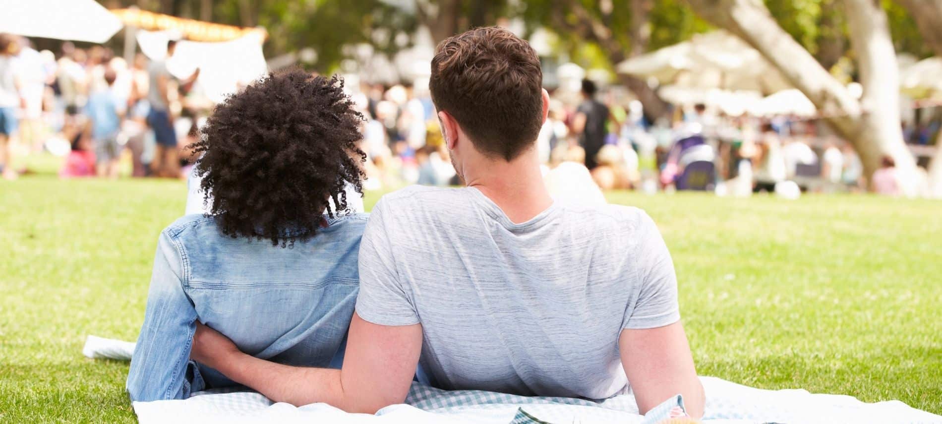 a couple relaxing on a blanket in a park during an event